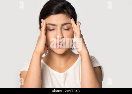 Betonte indische Mädchen Massage Tempel close up, leiden unter Kopfschmerzen. Stockfoto