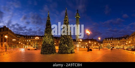 Panoramablick auf Place Vendome mit Weihnachtsbäumen in der Abenddämmerung. In der Mitte, der Vendôme-Säule mit der Statue von Napoleon. Paris, Frankreich Stockfoto