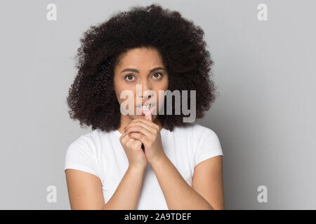 Kopf geschossen unsicheren afrikanischen amerikanischen Mädchen berühren Lippen, Zweifelnde Stockfoto