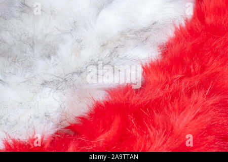 Pelz Textur Hintergrund. Rote und weiße flauschige Fell diagonal. Langer Flor. Stockfoto