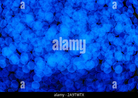 Beleuchtete abstrakte Runde tief Blau und Lila bokeh auf dunklem Hintergrund. Bunte Glitzer bokeh Aus Lupenansicht für Dekoration Lampen. Stockfoto