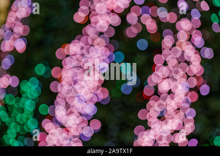 Bunte Glitzer beleuchtete abstrakte Rund, Rot, Lila, Blau, Grün und Magenta bokeh auf dunklem Hintergrund. Stockfoto