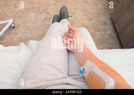 Die Hand des Patienten mit Faust mit Infusion Katheter. Erste Person anzeigen Stockfoto