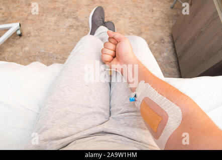 Die Hand des Patienten mit Faust mit Infusion Katheter. Erste Person anzeigen Stockfoto