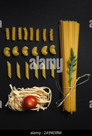 Verschiedene Formen von Nudeln und Spaghetti auf schwarzem Hintergrund. Stockfoto