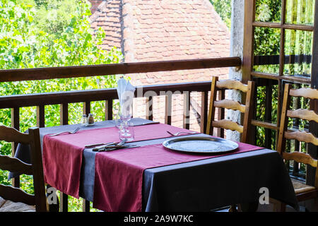 Esstisch durch ein offenes Fenster in einem Restaurant am Carennace, eines der schönsten Dörfer von Frankreich Stockfoto