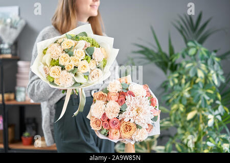 Zwei schöne Sträuße Gemischte Blumen in womans Hände. Die Arbeit der Florist in einem Blumenladen. Frische Schnittblume. Stockfoto