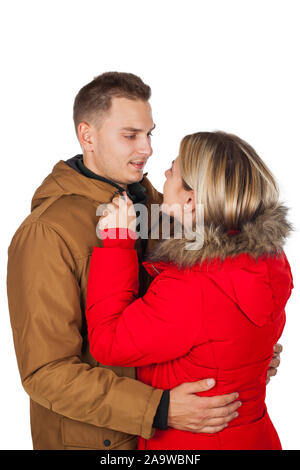 Junges Paar das Tragen der roten und braunen Winter parka Jacke posiert auf isolierten Hintergrund - Saisonale mode bekleidung