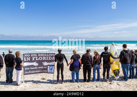 Miami Beach Florida, Surfrider Foundation, kein Offshore Florida Ölbohrprotest, schwarze Kleidung stellt Öl, Zeichen, Hand halten, Hände, Atlantischer Ozean, wa Stockfoto