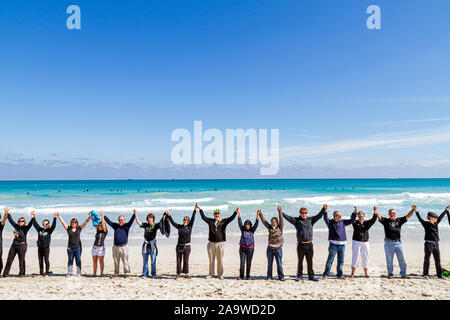 Miami Beach Florida, Surfrider Foundation, kein Offshore Florida Ölbohrprotest, schwarze Kleidung stellt Öl, Hand halten, Hände, Einheit, Atlantischer Ozean, w Stockfoto