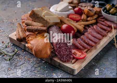 Close-up sortiert aus Fleisch und Käse auf ein Schneidebrett. Roh geräucherter Wurst, Schinken, Käse, Oliven. Stockfoto