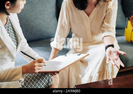 Kosmetiker, weibliche Kunden Fragen über ihren Lebensstil und Gewohnheiten und füllen den Fragebogen Stockfoto