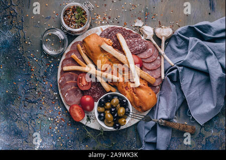 Ansicht von oben sortiert aus Fleisch und Käse auf einem runden Schneidebrett. Roh geräucherter Wurst, Schinken, Käse, Oliven. Kopieren Sie Platz. Mediterrane Küche Stockfoto