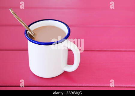 Vintage Kaffee Tasse mit Kaffee und Sahne auf rosa Holztisch gefüllt. Kaffee am Morgen. Stockfoto
