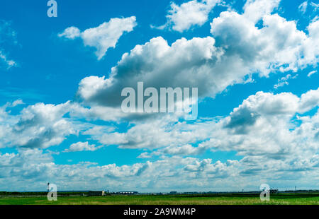 Landschaft grüne Rasenfläche und Zaun des Flughafens und schönen blauen Himmel und weiße flauschige Wolken. Schönes Wetter. Natur Landschaft. Bereich um Stockfoto