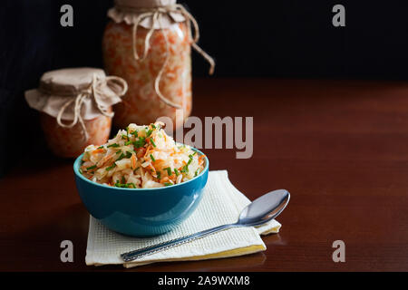 Fermentiertes Gemüse, Sauerkraut Salat in Gläsern und eine Schüssel auf einen dunklen Tisch. Copyspace. Bild horizontal Stockfoto