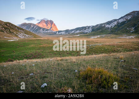 Berg Corno Grande leuchtenden rosa und golden im Licht des Sonnenaufgangs mit kargen Landschaft des Campo Imperatore in den Vordergrund, Abruzzen, Italien Stockfoto