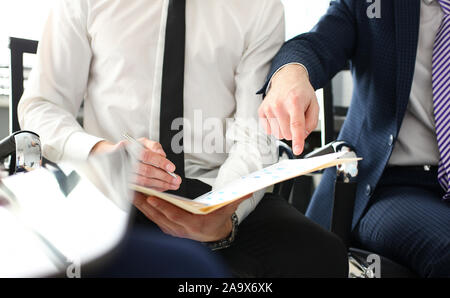 Männliche Hand in Anzug und Krawatte zeigen etwas Wichtiges in der Steuer interview Dokument Stockfoto