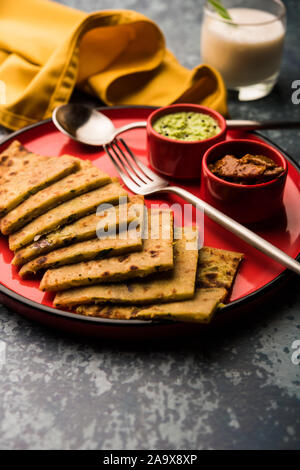 Aloo Paratha/Indischen Kartoffel gefüllte Fladenbrot mit Butter auf der Oberseite. Mit frischen süssen Lassi, Chutney und eingelegten Gurken serviert. selektive Fokus Stockfoto