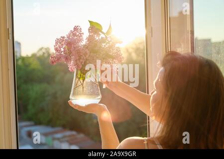 Strauß Blumen Flieder in Kanne in womans Hand Stockfoto