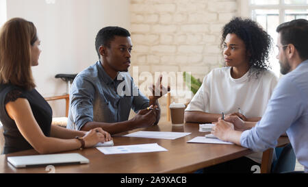 Afrikanische amerikanische junge Manager erklärt Forschungsergebnisse konzentrierten Mannschaftskameraden. Stockfoto