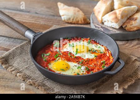 Shakshouka - pochierte Eier in Tomatensauce, in einer Pfanne serviert pan Stockfoto