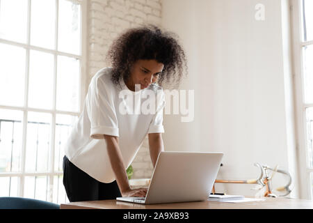 Junge afrikanische amerikanische Mitarbeiter schriftlich per E-Mail Antwort verwirrt. Stockfoto