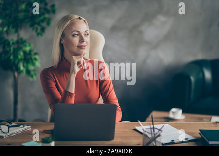 Foto von fröhlichen niedliche verträumte Frau suchen weit weg auf der Suche nach neuen Ideen für Startup sitzen am Tisch mit Laptop auf es Stockfoto