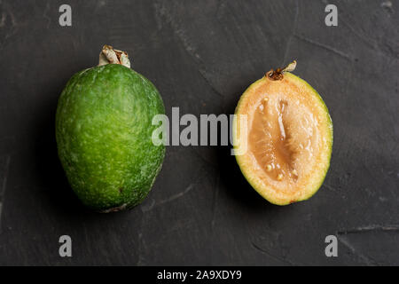 Tropische Früchte feijoa. Gesunde vegetarische Kost auf dunklen konkreten Hintergrund. Stockfoto