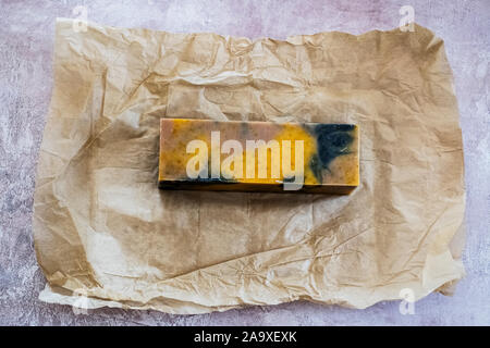 Hohen Winkel in der Nähe der gelb-schwarzen hausgemachten Seife auf braunem Papier. Stockfoto