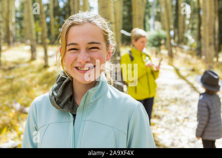 Eine reife Frau, Junge und Mädchen, eine Mutter und ihre zwei Kinder in Wäldern, Aspen Bäume im Herbst Farbe, Stockfoto