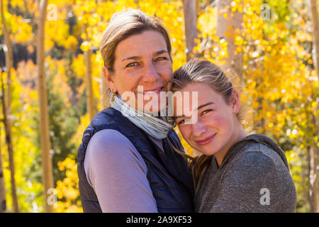 Portrait von Mutter und ihre 13 Jahre alte Tochter mit Herbst Espen in Hintergrund Stockfoto