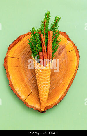 Zimt und grüne Zweige in einer Waffel kegel Fichte. New Year's Bouquet. Weihnachten null Abfall Stockfoto