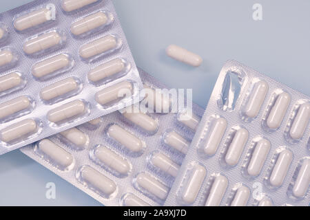 Weiße Kapseln in Silber Verpackung mit der Nahrungsergänzung von Zink und Selen gefüllt sind ungeöffnet liegen auf einem weißen Hintergrund. Stockfoto