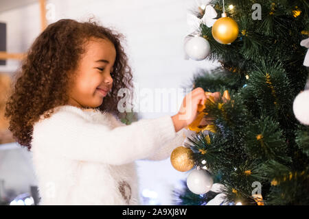 Cute afrikanische amerikanische Mädchen schmücken Weihnachtsbaum Stockfoto