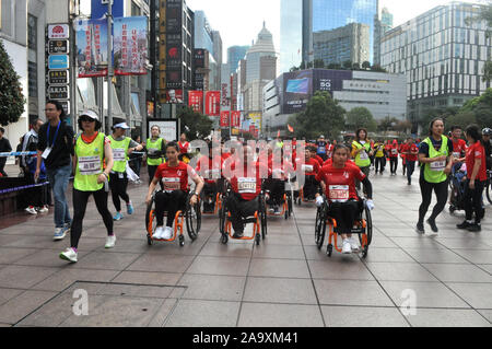 Die behinderten nehmen Sie Teil in die jährliche Shanghai Marathon mit ihren Rollstühlen in Shanghai, China, 17. November 2019. Stockfoto