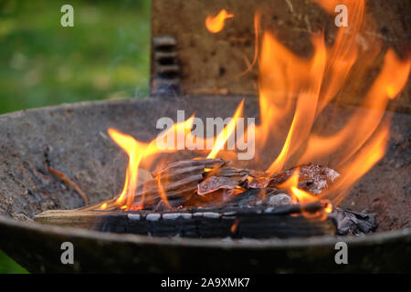 Flammen aus einem Haufen von Pappe, Papier, Holz und Reisig, bevor sie in ein Grill benutzt es oben zu erleichtern, bevor sie in die Holzkohle Stockfoto