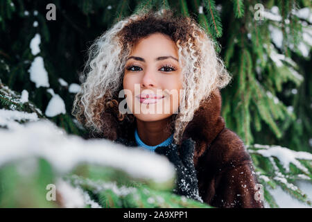 Close-up Portrait von schönen jungen afro-amerikanische Frau im Winter Wald Stockfoto