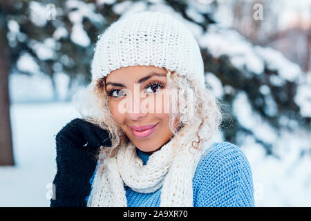 Lächelnden jungen Frau berühren Gesicht und Kamera in Winter Park. Stockfoto