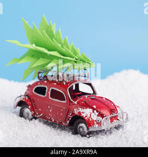 Nahaufnahme von Spielzeug retro Auto Volkswagen Käfer mit Weihnachtsbaum mit Schnee Stockfoto