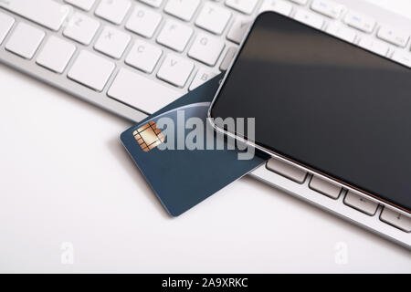 Mit schwarzem Bildschirm und Kreditkarte auf Laptop Tastatur Smartphone Stockfoto