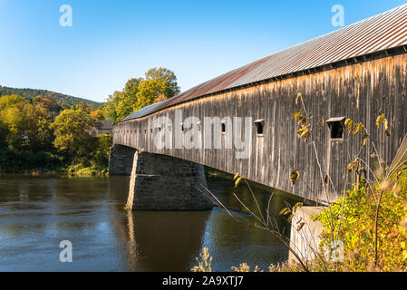 Alte hölzerne Brücke überspannt einen Fluss auf einer klaren Herbsttag. Cornish, NH, USA. Stockfoto