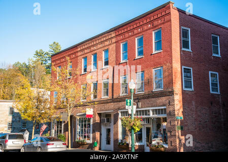 Traditionelle Amerika Backsteinbauten mit Geschäften auf der Straße an einem sonnigen Herbsttag. Woodstock, VT, USA. Stockfoto