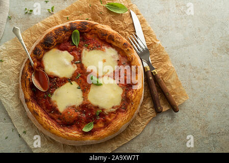 Pizza Margherita serviert mit Mozzarella, Tomaten und frischem Basilikum Stockfoto