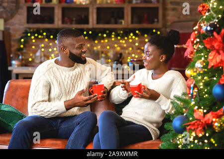 Romantische afrikanische amerikanische Paar heiße Schokolade trinken, genießen Winterurlaub Stockfoto