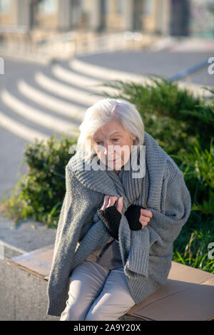 Grauhaarige obdachlose Frau Gefühl kalt und Elend Stockfoto