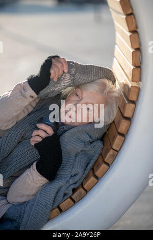 Obdachlose Rentner tragen graue Strickjacke und fühlen sich kalt Stockfoto