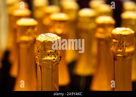 Champagner Flaschen in der Vinothek. perspektivische Ansicht Detail der goldenen Champagner flaschen Tops geordnet im Regal. Selektive konzentrieren. Stockfoto