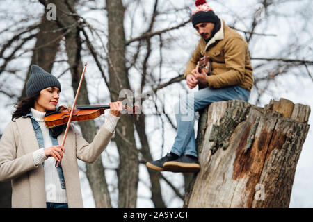 Die musikalischen Duett spielen Musik in einer schönen blattlosen Herbst Forrest Stockfoto