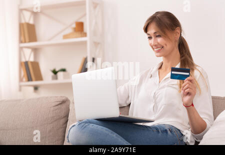 Gerne Frau mit Kreditkarte mit Laptop Shopping zu Hause Stockfoto